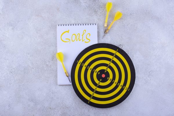 Target and goal concept with darts, arrows, and office accessories